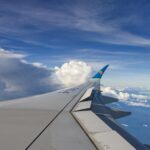 The wing of an airplane flying over the ocean