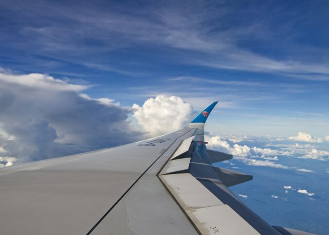 The wing of an airplane flying over the ocean