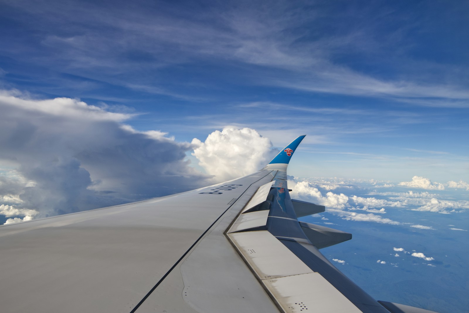 The wing of an airplane flying over the ocean