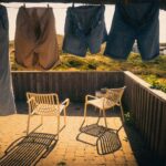 Clothes drying on a patio under bright sunlight, casting shadows on the ground.