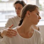 Two women engaged in a calming massage session, promoting wellness and relaxation.